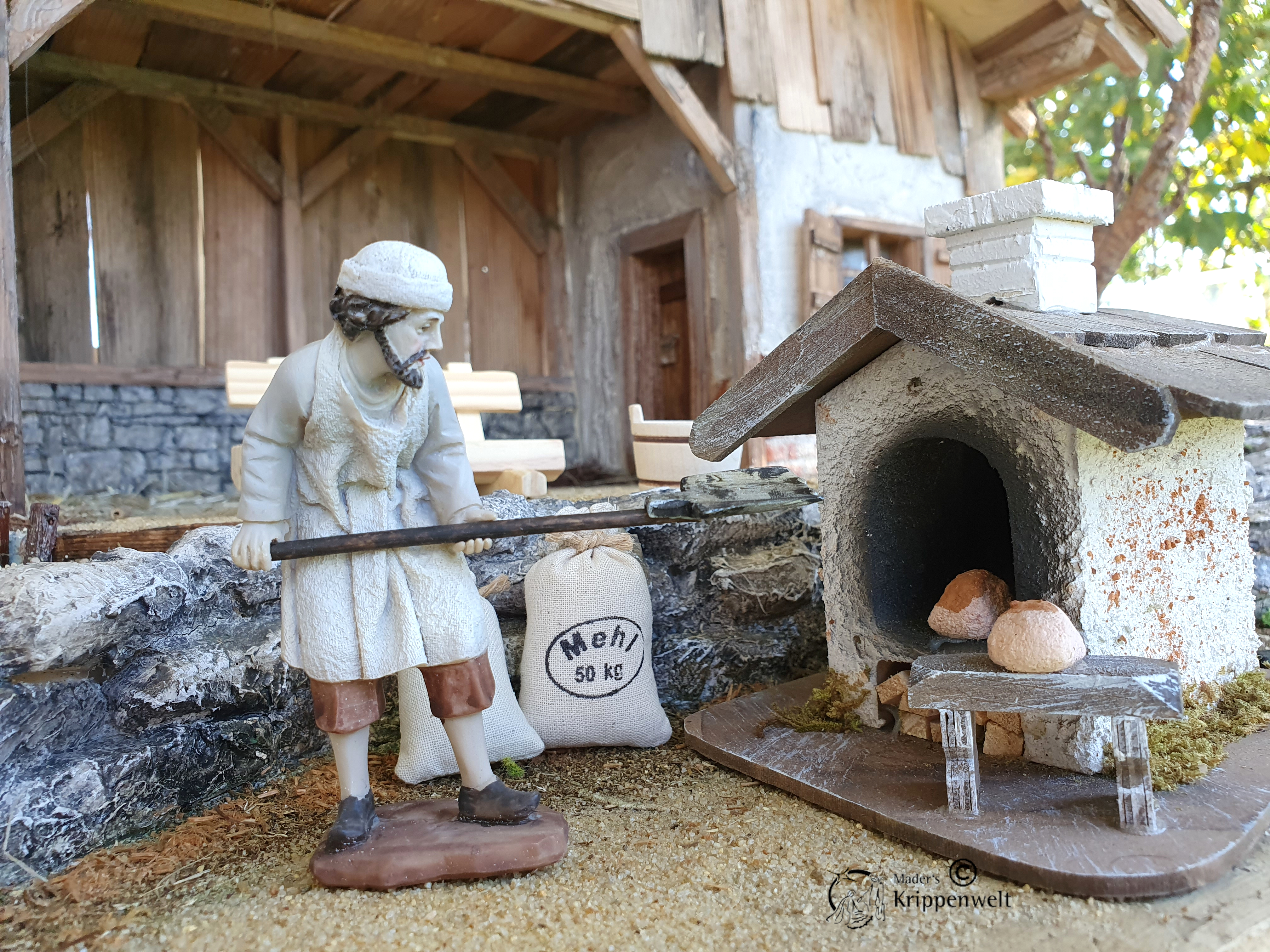 eine Bäcker mit Brotschieber beim Beladen eines Ofens